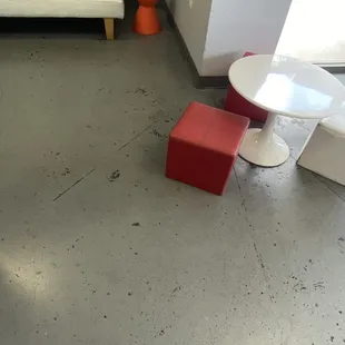 a living room with a white couch and red stools
