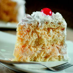 CAKE #37 ABACAXI C/ COCO: Moist and tender white cake filled with white mousse, freshcut pineapple and sweetened coconut shavings.