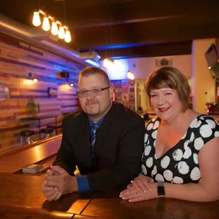 a man and a woman sitting at a bar