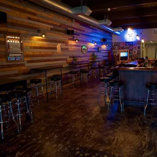 a bar with stools and a television
