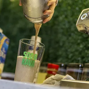 a person pouring something into a glass