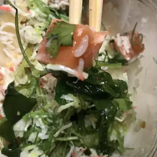 Salmon, greens, seaweed salad and cilantro.