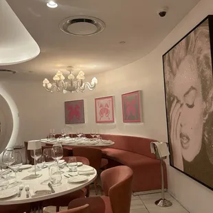 a dining room with a large painting on the wall