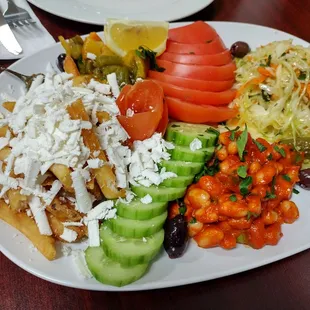 Side dish platter with feta fries, cabbage salad, Bulgarian bean side and shopska sides.