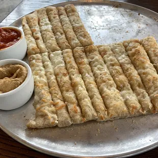 Sticks, (partially eaten), with marinara sauce and chipotle hummus