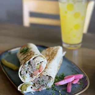 a burrito and pickles on a plate