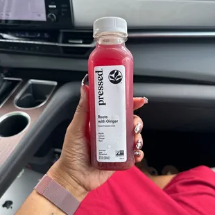 a person holding a bottle of juice