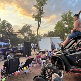 Ppl sitting on sxs watching a concert