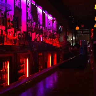 a dimly lit bar with neon lights
