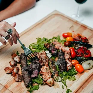 a person cutting meat on a cutting board