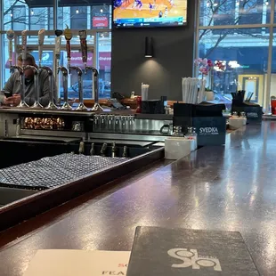 a bar with a large screen tv in the background