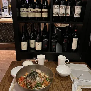 a bowl of noodles and wine on a table