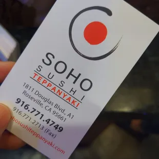 a hand holding a business card