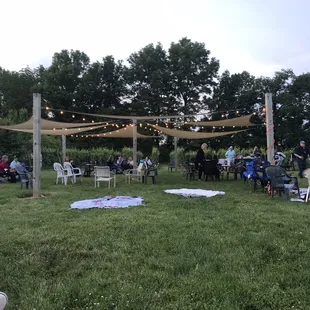a group of people sitting outside under a canopy