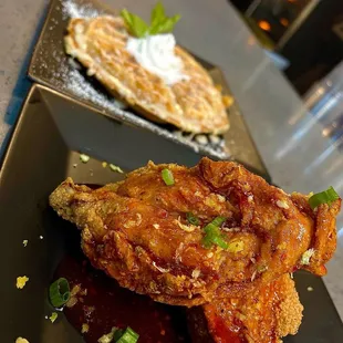 Hot honey country fried chicken paired with waffle topped with lemon buttercream icing and fresh whipped topping