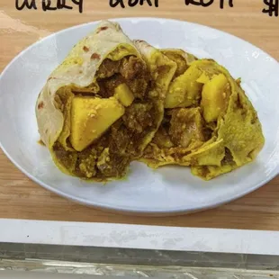 Curry Goat roti with potatoes.
