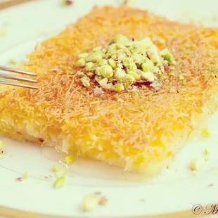 Kunafa ( shredded filo dough filled with cream .