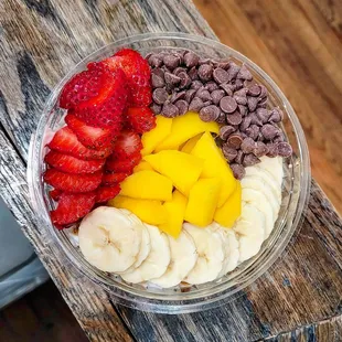 Build-your-own bol with plain Greek yogurt, gluten-free granola, strawberries, mango, carob chips, and bananas