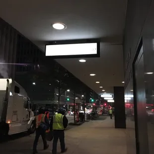 a group of workers walking down a sidewalk