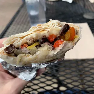 a hand holding a burrito