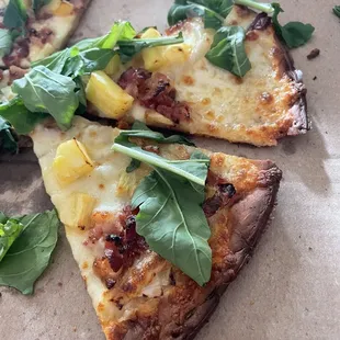 slices of pizza with greens on top