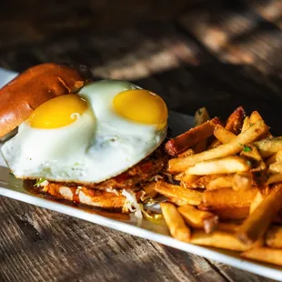 a plate of french fries with a fried egg on top