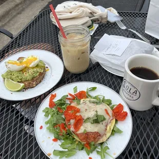 Avo toast with jammy egg (left) and mini garden veggie omelet (front) with an iced latte and hot coffee