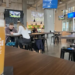 a woman sitting at a table with a glass of beer