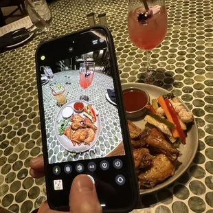 a person taking a picture of a plate of food