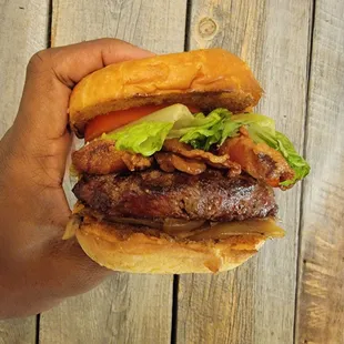 Angus burger on a brioche bun with bacon, lettuce, tomato and onion.