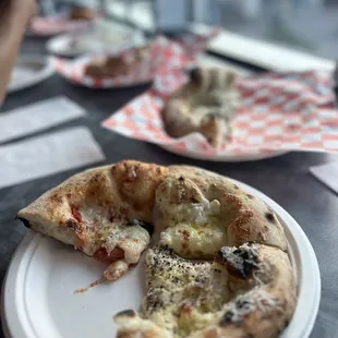 a slice of pizza on a paper plate