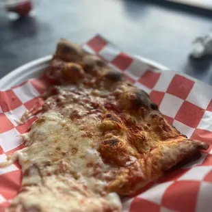a slice of pizza on a paper plate