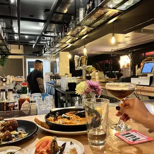 a table with plates of food and a glass of wine