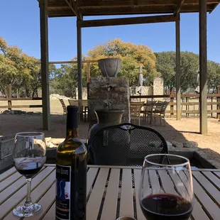 a table with two wine glasses and a bottle of wine