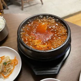 a hot pot of soup with rice and carrots