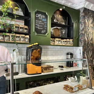a man standing in front of a counter with pastries