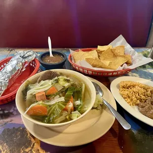 Large caldo de res, side of rice and beans, and homemade corn tortillas.