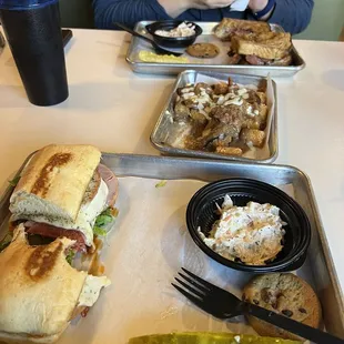 Italian sandwich, Reuben sandwich, pastrami poutine tots. Slaw, pickle, and cookie