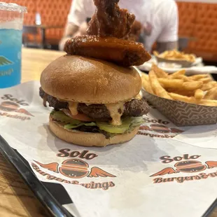 a man sitting at a table with a burger and fries