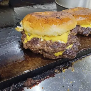 two burgers with cheese on them