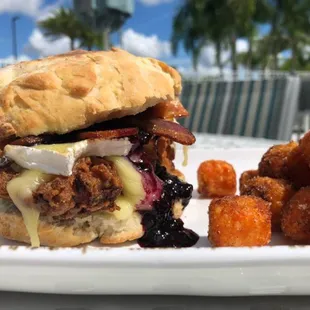 Chef Special Fried Chicken Biscuit: House-Made Biscuit, Berry Compote, Brie Cheese, and Bacon. Served w/ side of Candy Sweet Potato Tots.