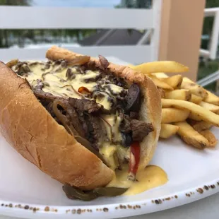 Chef Special Solara Cheesesteak: Sliced Tenderloin, Peppers, Onions, Mushrooms, House-Made Cheese Sauce and served with a side of fries.
