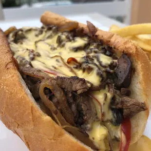 Chef Special Solara Cheesesteak: Sliced Tenderloin, Peppers, Onions, Mushrooms, House-Made Cheese Sauce and served with a side of fries.