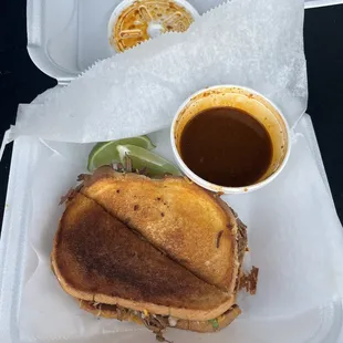 a grilled cheese sandwich with a side of sauce