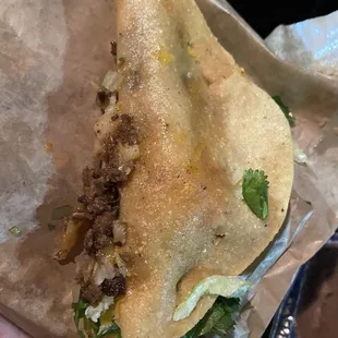 Broken taco with foods spilling out everywhere. Messy too.