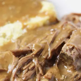 a plate of food with gravy and mashed potatoes