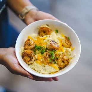 a person holding a bowl of food