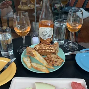 a plate of cheese, crackers, and wine