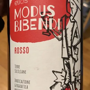 a hand holding a bottle of wine