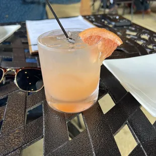 a grapefruit cocktail on a table